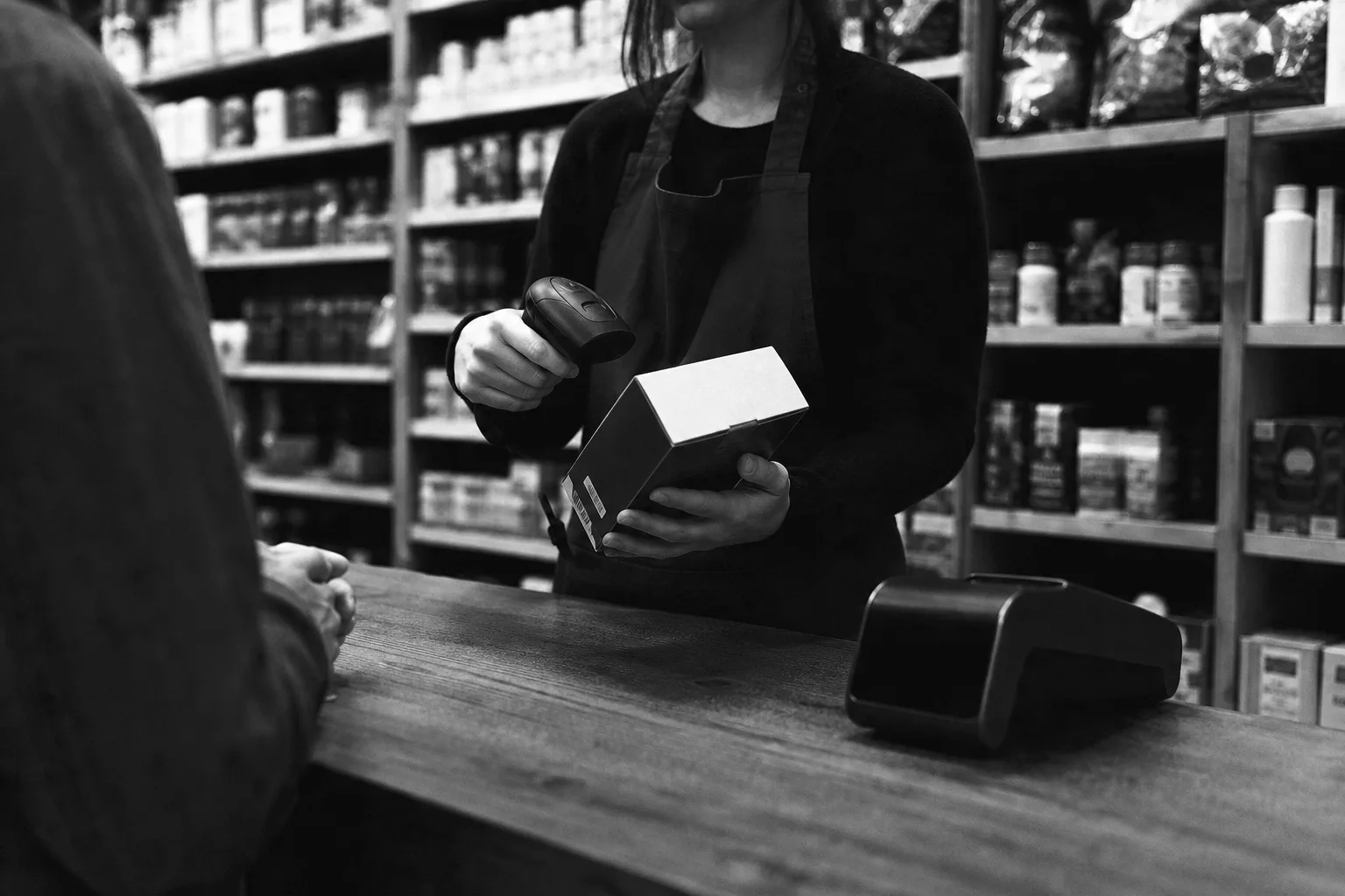 Vendedora escaneando un producto con lector de código de barras en el mostrador de una tienda